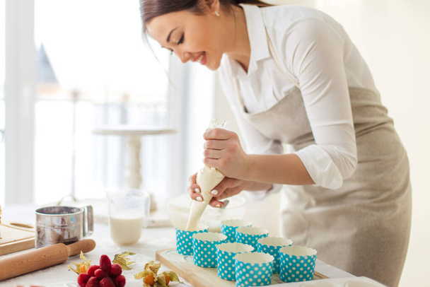 positive female chef enjoys cooking - Фото, зображення