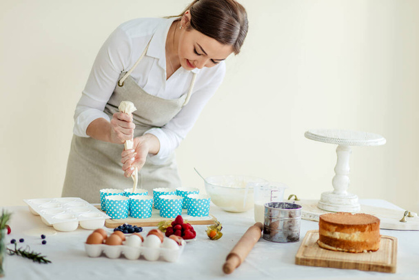 attractive girl using resealable plastic bag to cook cupcakes - Fotografie, Obrázek