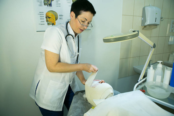 Посещение косметолога. Доктор чинит маску. Процедура карбоксиотерапия. - Фото, изображение