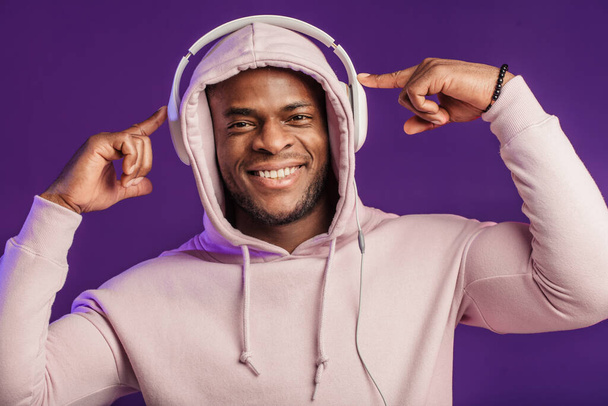 African man in hoodie with headphones isolated, happy expression. Music, people - Foto, Imagen