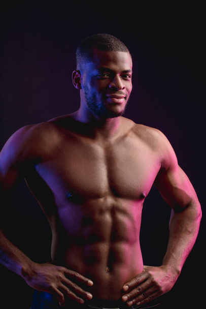 Fit young African sports king man with torso, isolated on dark background. - Foto, immagini
