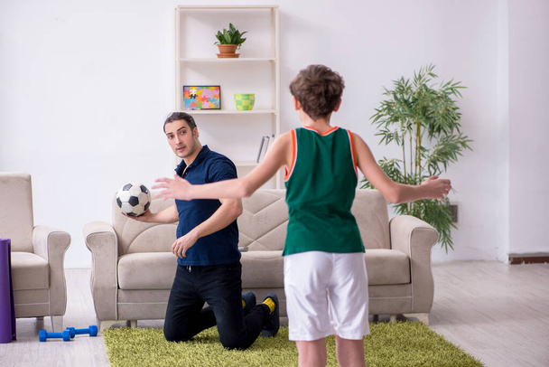 Father and son doing sport exercises indoors - 写真・画像