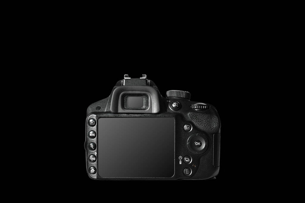 Eine professionelle Digitalkamera mit großem Touchscreen, viele Tasten erleichtern die Bedienung der Kamera. Kamerablick von hinten auf schwarzem Hintergrund. - Foto, Bild