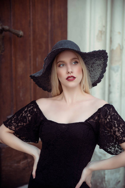 Gorgeous young woman in black hat posing  - Foto, imagen