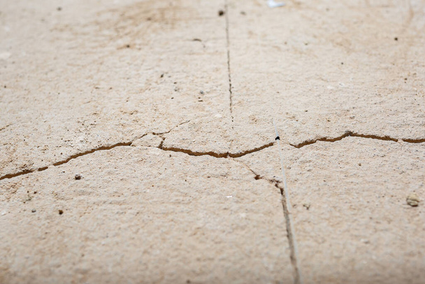 Cracks in the concrete cement screed on the floor after repair. The concrete surface texture is covered with web cracks. Gray stone background - Photo, Image