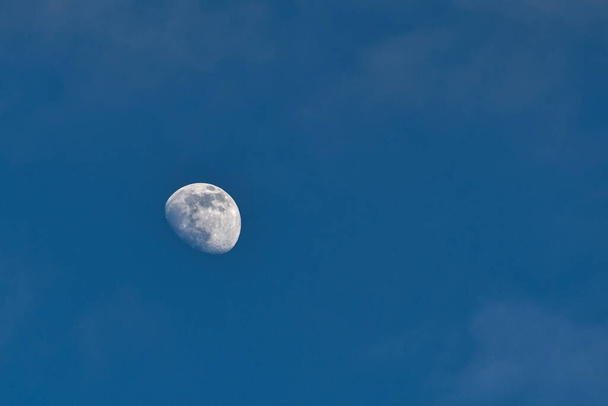 Osservazione della luna contro il cielo, chiaramente visibile satellite di terra artificiale. Una vista da terra sul quadrante della luna con crateri ben visibili. - Foto, immagini