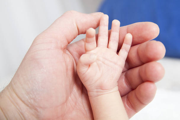 Houd een hand van het pasgeboren kind - Foto, afbeelding