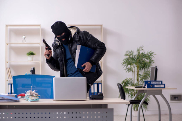 Junger männlicher Einbrecher im Büro - Foto, Bild