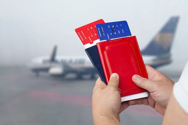 Il est temps de voyager. Un homme tient des billets et des passeports en arrière-plan de l'avion - Photo, image