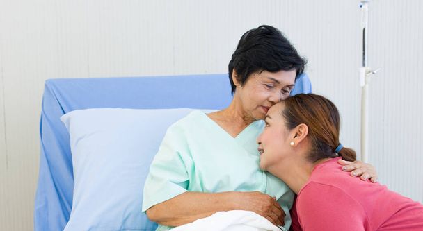 Прекрасная дочь приходит навестить больную мать, пока её мама восстанавливается в больнице. Концепция здравоохранения для пожилых людей. - Фото, изображение