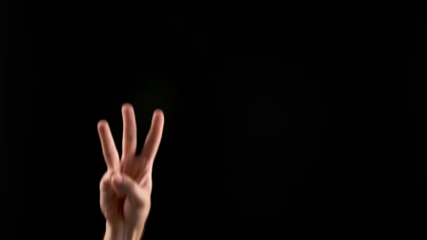 Ręcznie pokazująca literę W na ciemnym tle. Alfabet języka migowego - Materiał filmowy, wideo