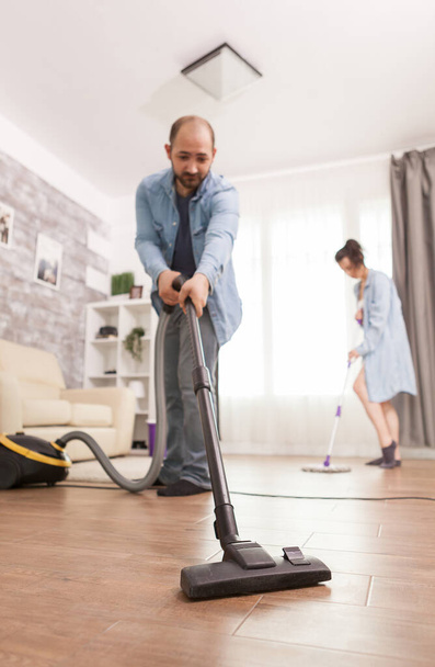 Cleaning floor with vacuum cleaner - Фото, изображение