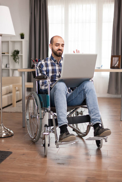 Бізнесмен в інвалідному візку, що працює на ноутбуці
 - Фото, зображення