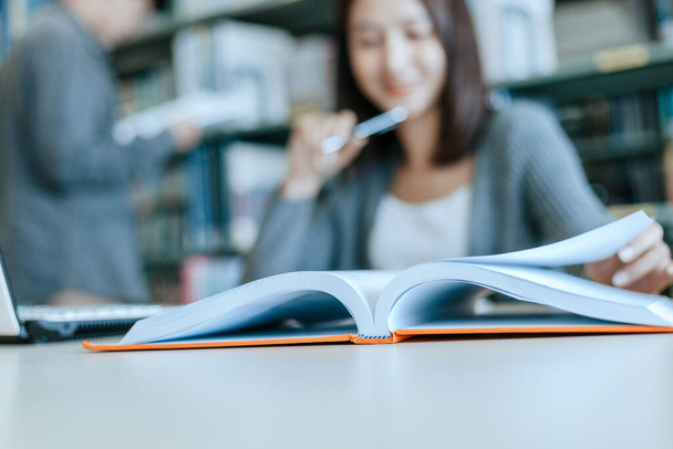 Student open a book and read for exam in the library. Education concept. - 写真・画像