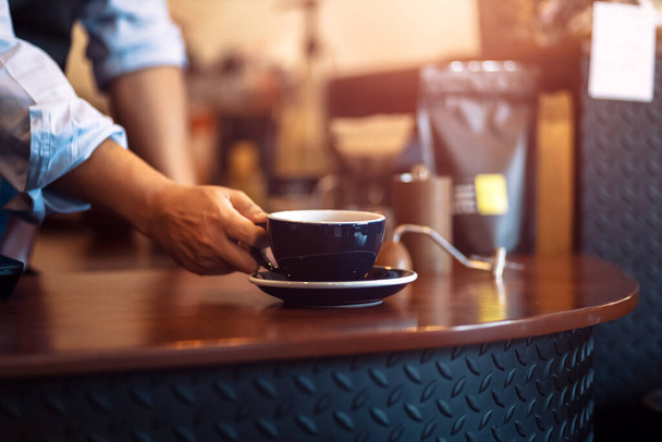 Barista serving cup of coffee on the table  - Foto, imagen
