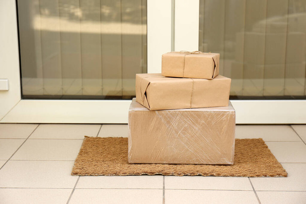 Delivered parcels on door mat near entrance - Foto, Imagem
