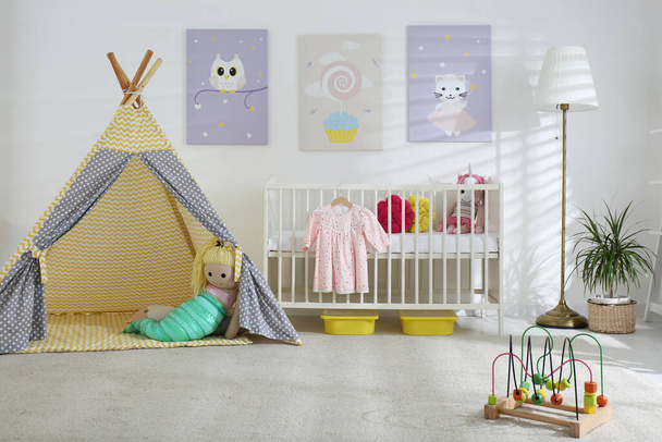 Baby room interior with cute posters, play tent and comfortable crib - Фото, изображение