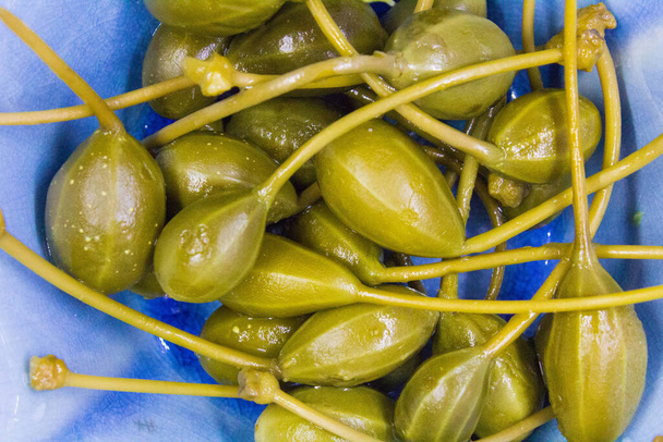 fruit of the caper flower ready for finger food served in a light blue bowl - Photo, Image