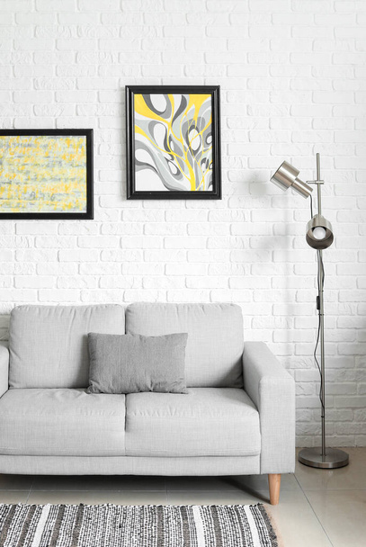 Стильний інтер'єр вітальні з диваном і лампою
 - Фото, зображення