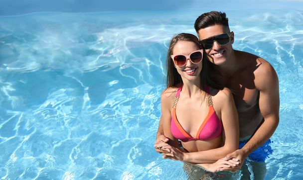 Happy couple in outdoor pool on sunny summer day. Space for text - Photo, Image