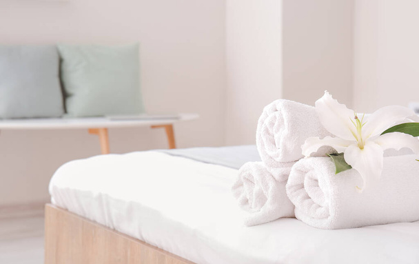 Serviettes propres sur le lit dans la chambre d'hôtel - Photo, image