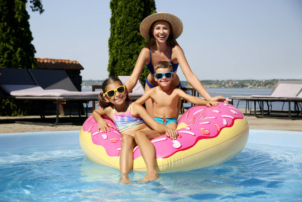Woman with her children in swimming pool. Family vacation - Фото, зображення