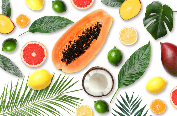 Tropical layout with fresh exotic fruits and green leaves on white background, top view - Photo, Image