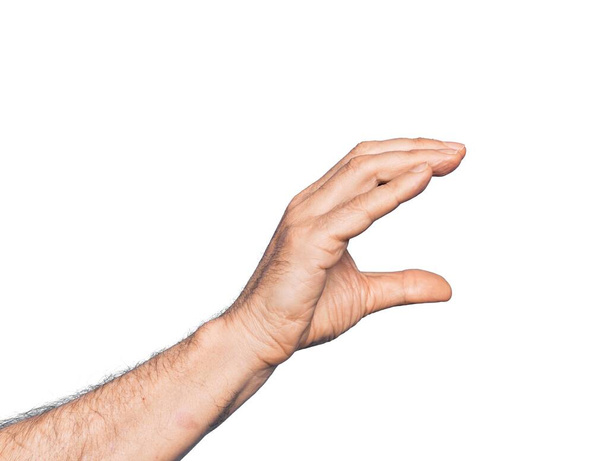 Рука кавказького чоловіка середнього віку над ізольованим білим тлом, який бере невидиму річ, тримаючи об'єкт пальцями, показуючи простір
 - Фото, зображення