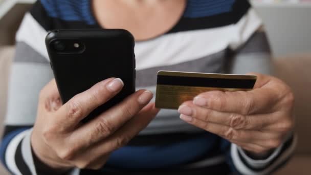 Zblízka zákazník drží kreditní kartu a smartphone. Žena nakupující pomocí okamžité snadné mobilní platby, aby nákup v internetovém obchodě. Služba aplikace e-banking - Záběry, video
