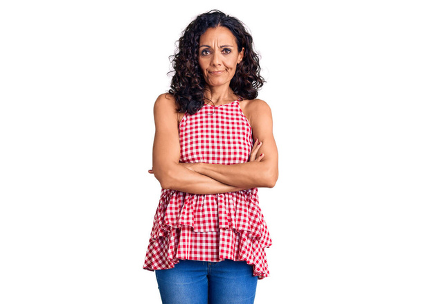 Middle age beautiful woman wearing casual sleeveless t shirt skeptic and nervous, disapproving expression on face with crossed arms. negative person.  - Photo, Image