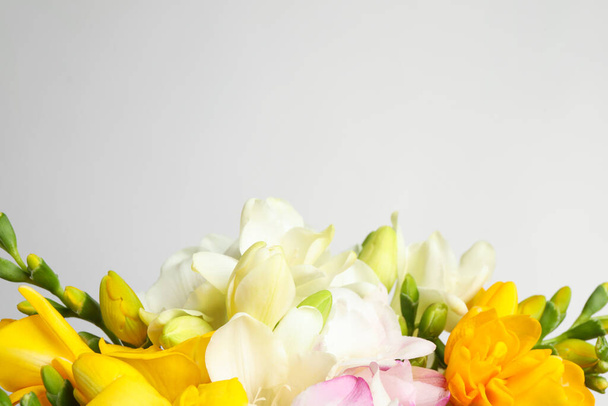 Beautiful colorful freesia bouquet on grey background, closeup. Space for text - Foto, Imagem