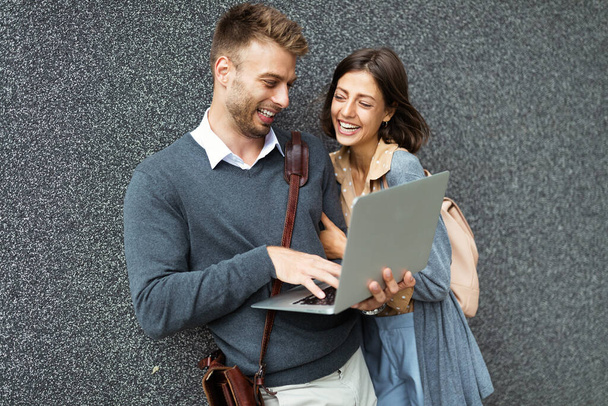 Happy woman and man using laptop outdoor. Travel, business, technology, people fun concept - Photo, Image