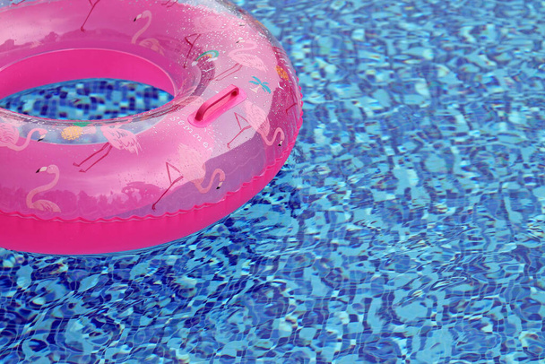 Różowy gumowy pierścionek w basenie. Koncepcja letnia. - Zdjęcie, obraz