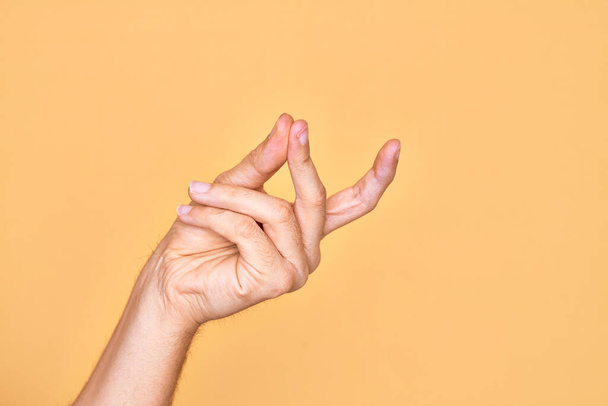 Käsi valkoihoinen nuori mies näyttää sormet yli eristetty keltainen tausta napsauttamalla sormet menestys, helppo ja valitse symboli ele käsin - Valokuva, kuva