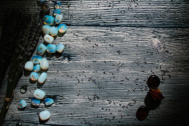 Tavolo in legno con attributi occulti, vista dall'alto. Pietre runiche, lavanda secca. Spazio di copia vuoto - Foto, immagini