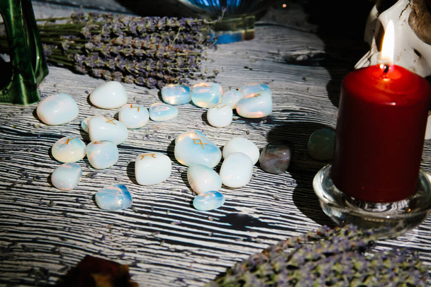 Tavolo in legno con attributi occulti, vista dall'alto. Pietre runiche, candele, lavanda secca, rosari. Spazio di copia vuoto - Foto, immagini