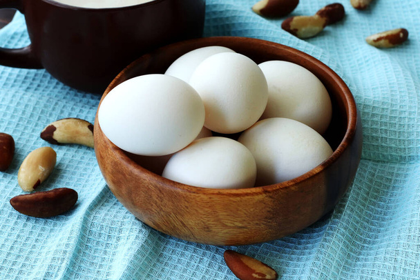 eggs in a basket, nuts , a cup of milk, blue napkin - Foto, Bild