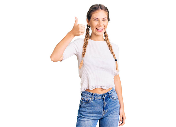 Красива біла жінка з білявим волоссям, одягнена в коси і біла сорочка посміхається щасливим і позитивним, великий палець робить відмінний знак схвалення
  - Фото, зображення