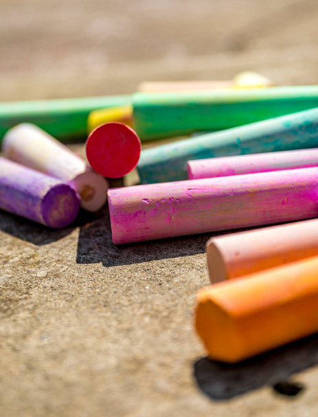 Πολύχρωμα κιμωλίες σε ποικιλία χρωμάτων τοποθετημένα σε μπετόν φόντο. - Φωτογραφία, εικόνα