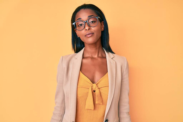 Young african american woman wearing business clothes relaxed with serious expression on face. simple and natural looking at the camera.  - Фото, зображення