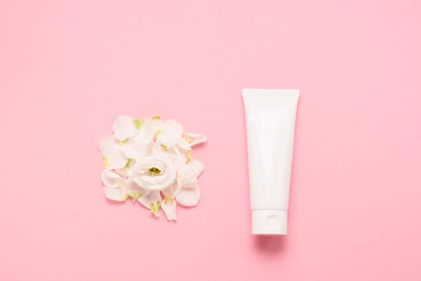 Hand cream with flowers. Delicate skin care concept. Top horizontal view copyspace. - Photo, Image