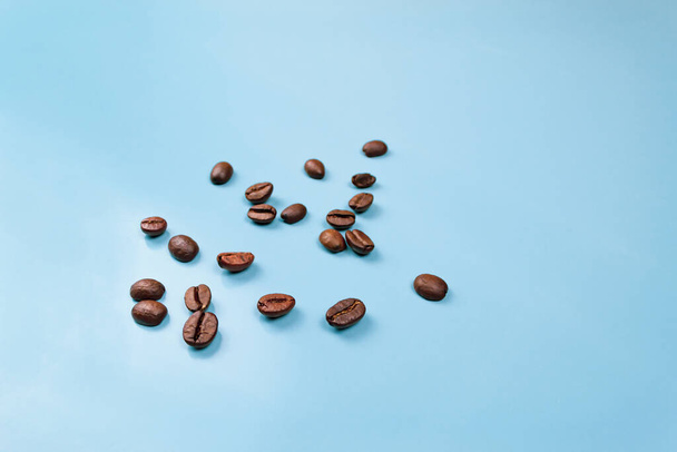 grains de café saupoudré sur fond bleu gros plan - Photo, image