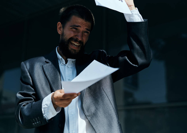 Ділова людина на відкритому повітрі з документами в руках біля будівництва офіційного способу життя
 - Фото, зображення