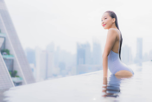 retrato hermosa joven asiática mujer relajarse sonrisa ocio alrededor al aire libre piscina en hotel resort - Foto, imagen