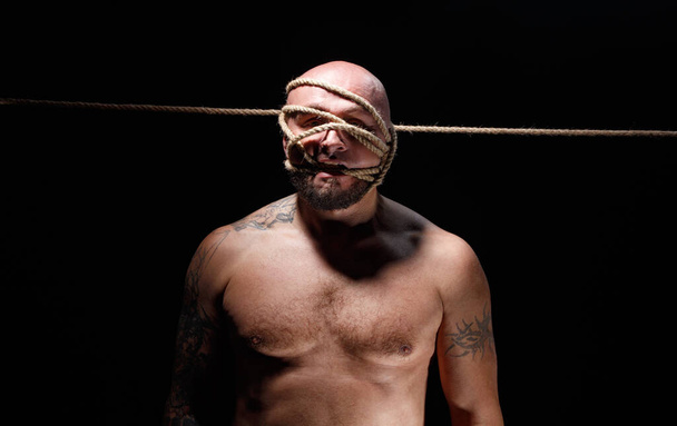 Foto de homem careca com corda no rosto e tronco nu - Foto, Imagem