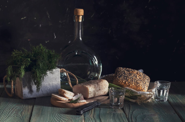Martwa natura. Smalec, domowej roboty wódka, zielona cebula, koperek i chleb na drewnianym stole z bliska (ukraińska i rosyjska przystawka narodowa) - Zdjęcie, obraz