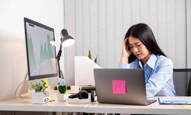 Pracujące Azjatki czują się zestresowane, zmęczone pracą, migrenowe bóle głowy po ciężkiej pracy w biurze. - Zdjęcie, obraz
