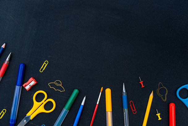 Office and school supplies on black board background. Copy space. Back to school concept. - Photo, Image