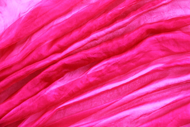 texture of transparent pink fabric with pleats a spiral and diagonal - Fotó, kép