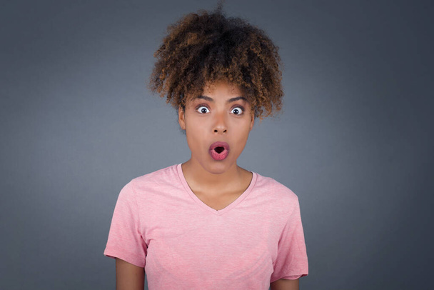 Headshot of goofy surprised bug-eyed Young beautiful African American staring at camera with shocked look, expressing astonishment and shock, screaming Omg or Wow - Photo, Image
